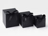 Three black softbox gift boxes with ribbons on a white background
