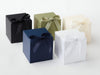 Four softbox XL cube gift boxes in black, green, blue, and white with ribbons on a white background