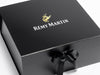 Rémy Martin Gold and White Foiled Logo on Black XL Deep Gift Box with a bow on a white background