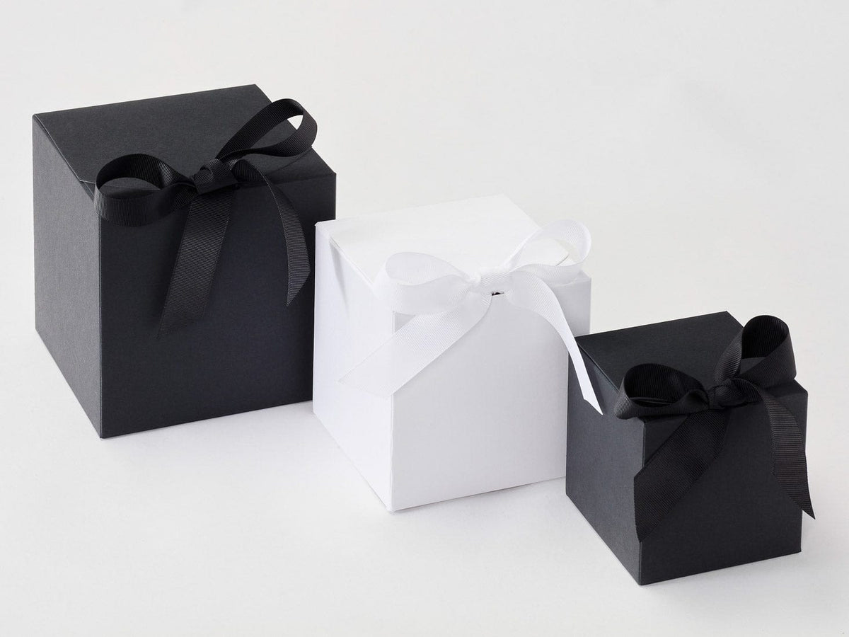 Two black Softbox gift boxes with ribbons and a white gift bag on a White background