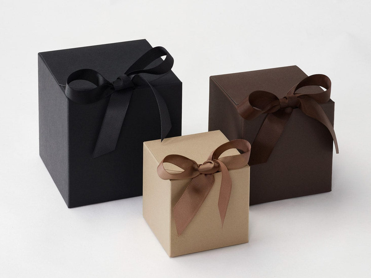 Three softbox gift boxes with ribbons in black, brown, and Taupe on a white background